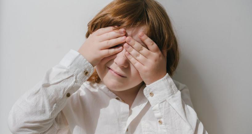 a small child keeping his hands on eye due to eye strain